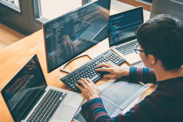 man-typing-using desktop-and laptop